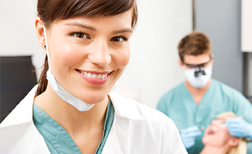 Dentist and dental assistant working on patient